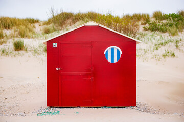 Red beachhouse with window on the beach.