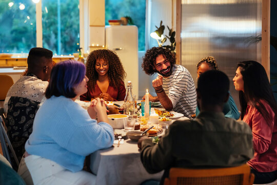 Multiracial friends gathering around table