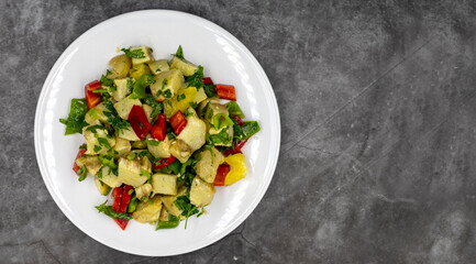 Artichoke salad with olive oil on dark background. Traditional delicious Turkish food; (zeytinyagli enginar). Top view. Copy space. Empty space for text.