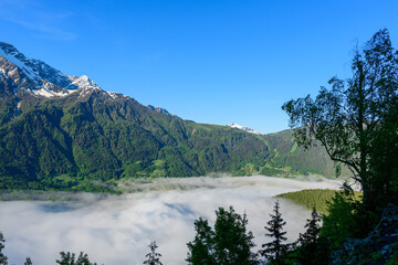 Clouds over the valley towards Les Houches in the Mont Blanc massif in Europe, France, the Alps, towards Chamonix, in summer on a sunny day.