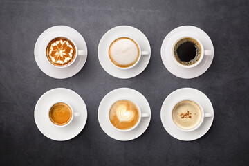 Flay lay of coffee cup assortment isolated on dark background.