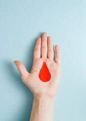 Minimalist concept of a red drop of blood on the palm..Humanitarian donation.