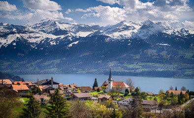 Fototapeta na wymiar Village Sigriswil on the hills over the Lake Thun with Bernese Alps