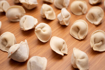 Fototapeta na wymiar Frozen uncooked dumplings pelmeni on a wooden board