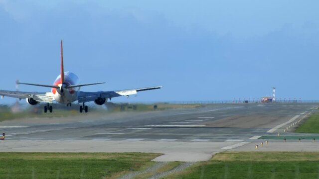 Passenger Airplane Flare and Landing on the Runway, Sunny Day, Behind.