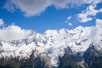 A panoramic view of the Mont Blanc Massif and its snows in the Mont Blanc Massif in Europe, France, the Alps, towards Chamonix, in summer, on a sunny day.