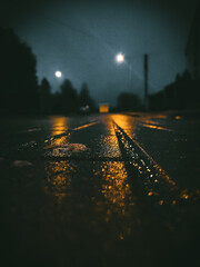 Zdjęcie drogi po deszczu z latarniami w tle  - obrazy, fototapety, plakaty