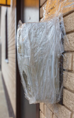 Broken electric meter wrapped in duct tape on the wall