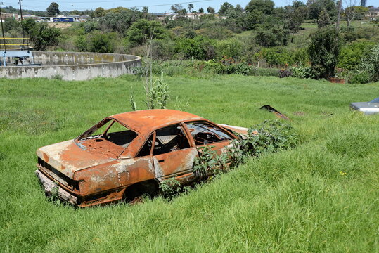 Rusted vehicular wreck abandoned in a wastewater treatment facility
