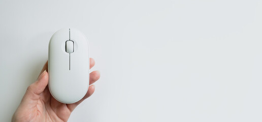 Computer white mouse in hand on a white background in banner format. Computer equipment and accessories