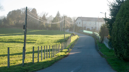 Carretera rural junto a pradera y granja