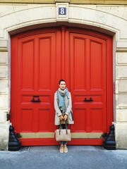 woman in front of a red door of a historic building