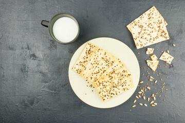a plate of whole-grain homemade cookies and a mug of milk on a black background. healthy eating. top view.
