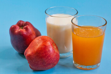 Healthy food with apples, fruit juice and  a glass of milk  in closeup on blue background	