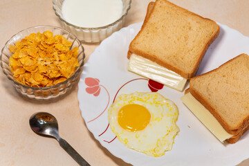 Healthy Indian breakfast of brown bread with cheese slice and poached egg served with corn flakes...