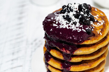 stack of corn pancakes with blueberry jam, closeup