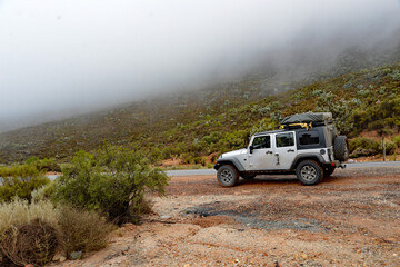 An offroad vehicle parked on a misty day