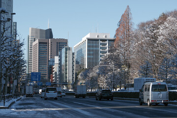 Fototapeta na wymiar 雪が降った青山通りの風景。用心深く自動車が走る。東京、赤坂7丁目の街の風景