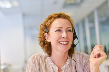 Young woman as operator with headset in the service hotline