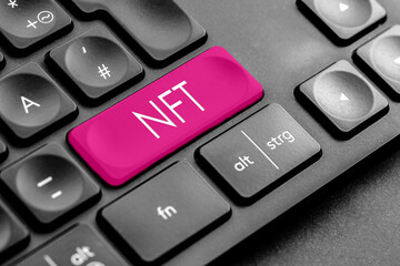 pinke "NFT" Taste auf einer dunklen Tastatur