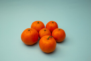 Bright orange tangerines lie on a blue background