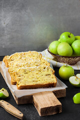 Apple and coconut loaf cake on wooden cutting board