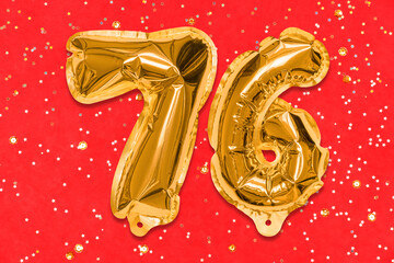 The number of the balloon made of golden foil, the number seventy-six on a red background with sequins. Birthday greeting card with inscription 76. Numerical digit, Celebration event, template.