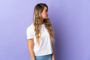 Fototapeta premium Young Brazilian woman isolated on purple background looking to the side