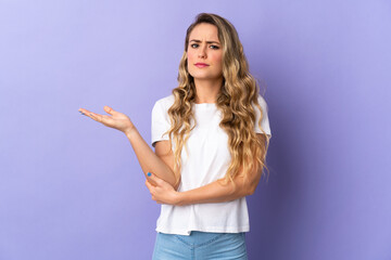 Young Brazilian woman isolated on purple background having doubts