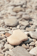 Pebble stones background close-up. Vertical pattern of gray stone surface with selective focus.