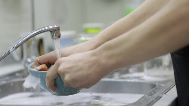 washing dirty dishes, cleaning the kitchen, slow motion video
