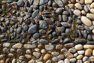 perpendicular view of a pavement of black and white river pebbles