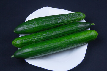 Green cucumbers on a white plate 