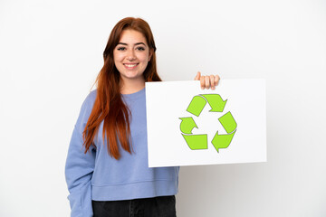 Young redhead woman isolated on white background holding a placard with recycle icon with happy expression