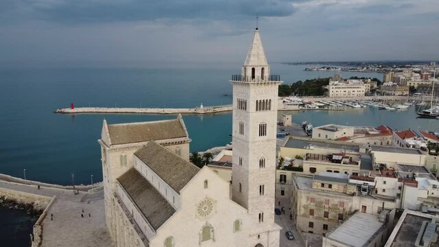 Circle e zoom out con drone sulla citt&agrave; Trani andando all'indietro ruotando da sinistra verso destra girando attorno al campanile della cattedrale aprendo sul porto e centro storico