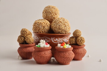 Til Gul OR Sweet Sesame seed ball or Laddu with Fikri for Indian festival Makar Sankranti over white background.