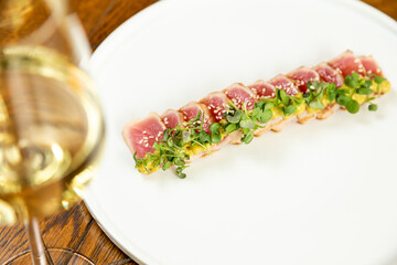 tuna on a white plate garnished with fresh herbs