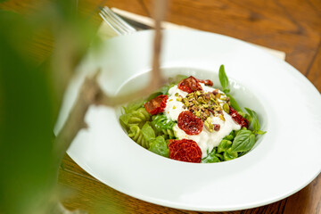 fusili pasta with sun-dried tomatoes and mousse garnished with fresh basil
