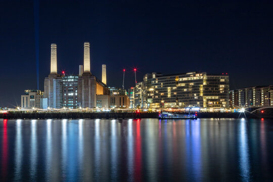 The newly renovated Battersea Power Station and apartments, night shot, reflected in River Thames, Nine Elms, Wandsworth, London