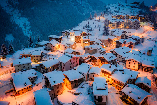 Christmas lights on mountain houses and chalets covered with snow at dusk, Pianazzo, Madesimo, Valle Spluga, Valtellina, Lombardy, Italy