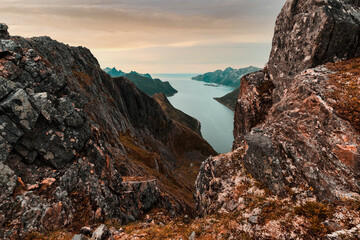 Oyfjorden fjord view from steep hiking trail through red rocks of mountains, Senja island, Troms county, Norway, Scandinavia