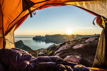 Warm lights of sunrise view from the inside of hiker's tent, Senja island, Troms county, Norway, Scandinavia