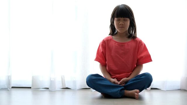 Asian girl meditating, lovely kid
