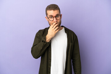 Fototapeta na wymiar Young handsome caucasian man isolated on purple background surprised and shocked while looking right