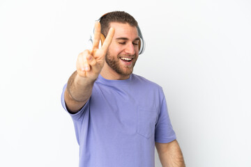 Young handsome caucasian man isolated on white background listening music and singing