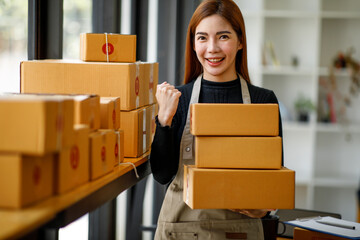 Startup small business entrepreneur SME or freelance woman using a laptop with box, AsianYoung...