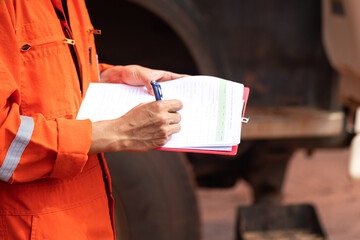 Safety officer or Supervisor is writing note on the checklist paper during perform audit and...