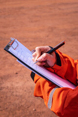 A supervisor is taking note on paper during perform inspection audit and safety group meeting....