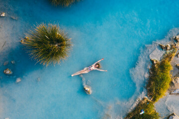 Natural Spa in Saturnia, Tuscany, Italy. Girl relaxing in hot spring. Drone photography