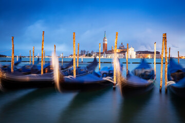 Gondolas moored by Saint Mark square with San Giorgio di Maggiore church in Venice